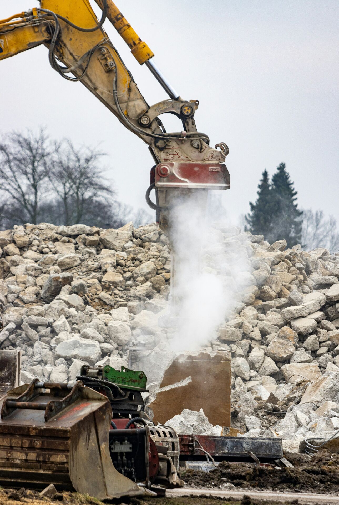 Excavator processing demolition rubble for waste diversion
